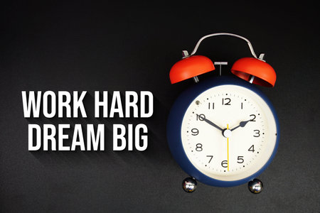 Work Hard Dream Big text with alarm clock on black background