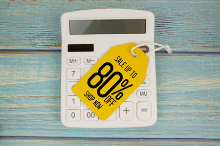Sale up to 80% off Shop Now with price tag and calculator on wooden background