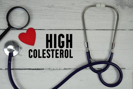 High Cholesterol text with Red heart, Magnifying glass and Medical Stethoscope on wooden backgroundの写真素材