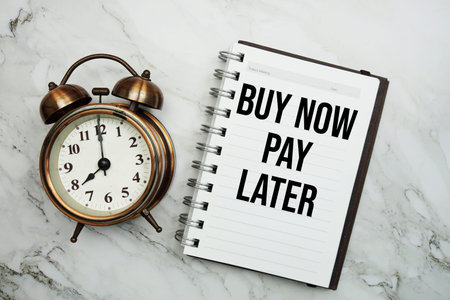 Buy Now Pay Later text written on notepad with alarm clockの写真素材