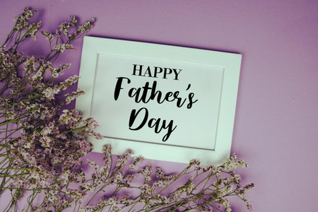 Happy Father's Day text with flowers bouquet decoration on purple backgroundの写真素材