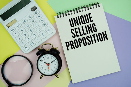 Unique Selling Proposition text with calculator, alarm clock and magnifying glassの写真素材