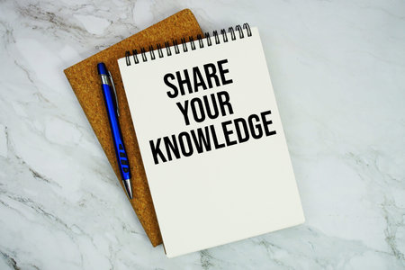 Share Your Knowledge text written on notepad with pen on marble background