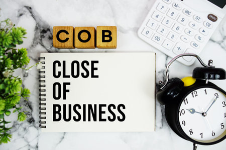 COB Close of Business text with calculator and alarm clock on marble background
