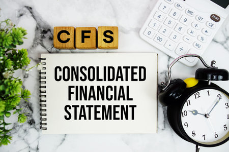 CFS Consolidated Financial Statement text with calculator and alarm clock on marble backgroundの写真素材