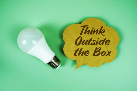 Think Outside the Box text written on speed bubble with light bulbの写真素材