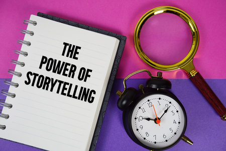 The Power Of Storytelling text written on notebook paper with magnifying glass and alarm clock