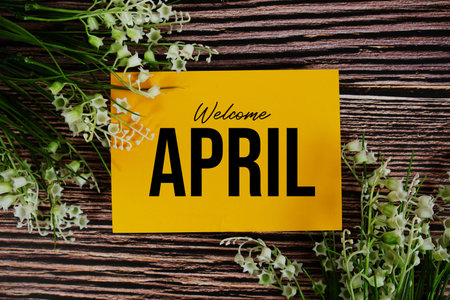 Welcome April text written on paper card with flower decorations