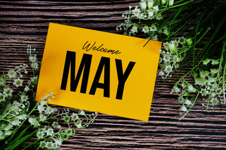 Welcome May text written on paper card with flower decorations