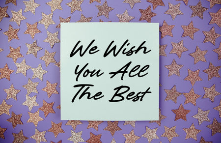 We Wish you all the Best text on paper card with star glitter decoration flat lay on purple backgroundの写真素材