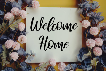 Welcome Home text with flower decoration on wooden background