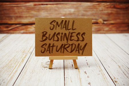 Small Business Saturday text message with easel on wooden background
