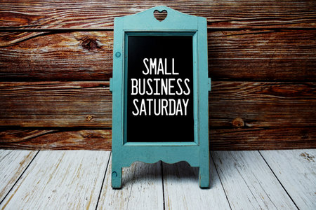Small Business Saturday text message with easel on wooden background