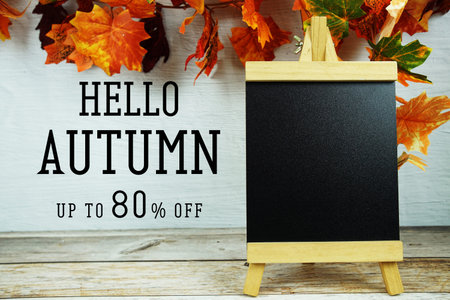 Autumn Sale 80% text with maple leaf decoration on wooden background