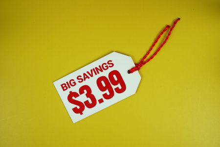 Big Savings $3.99 text message on price tag top view on yellow background, business and promotion concep