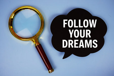 Follow Your Dreams text on speech bubble with magnifying glass on blue background