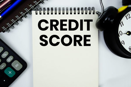 Credit Score text written on notepad with calculator and alarm clock