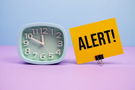 Alert! text and alarm clock on blue and purple background