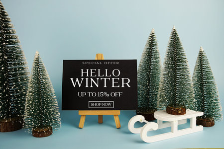 End of Year Sale 15% off text with easel and Christmas tree on blue background