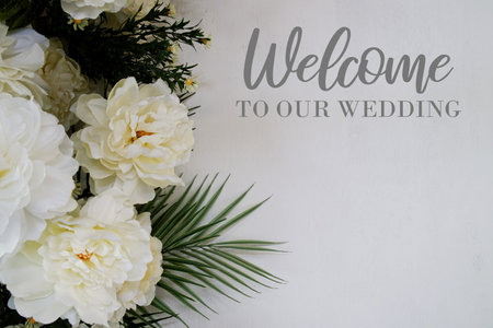 Welcome to Our Wedding text with flowers decoration on wooden background