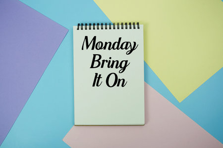 Monday Bring It On text written on notepad flat lay on multicolor pastel background