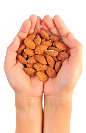 Almonds in hand isolated on whiteの写真素材
