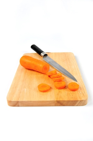 Sliced carrots and a knife on a cloth timberの写真素材