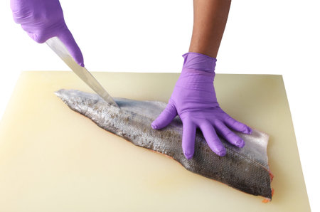 Chef cutting salmon fish on fillets with knifeの写真素材