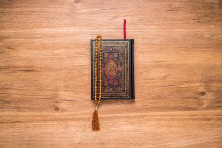 The Holy Al Quran and rosary beads or tasbih, on wooden tableの写真素材