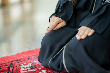 The image of an Asian Muslim woman in the Islamic religion in hijab in cream and black color. She was praying in a beautiful mosque out of respect for God.の写真素材
