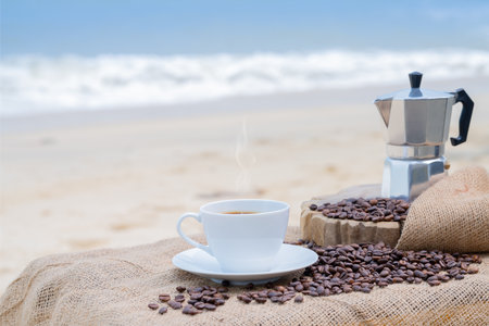 Close-up white coffee cup and many coffee beans placed around on wood table with a beautiful seascape of nature background, concept coffee vacation travel.の写真素材