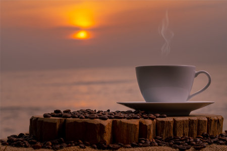 Coffee cup and coffee beans on wooden table with sunrise backgroundの写真素材