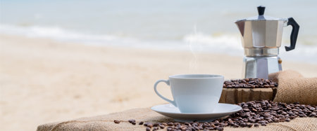 Close-up white coffee cup and many coffee beans placed around on the wood table with a beautiful seascape of nature background, concept coffee vacation travel.の写真素材
