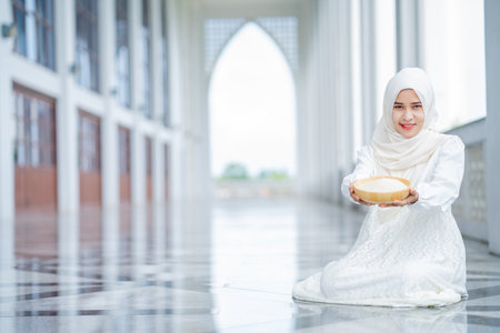 Muslim Hands are holding a wooden bowl of rice grains for zakat, an Islamic zakat concept. Muslims to help the poor and needy. Conceptual shoot for property, income,の写真素材