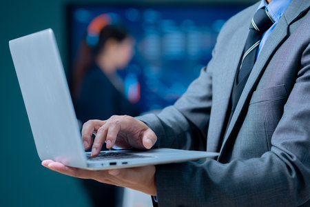 Businessman working on laptop in office. Close-up of male hands typing on laptop keyboard.の写真素材