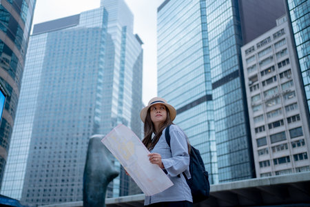 Asian tourist, cute woman with long hair are traveling in Hong Kong along with map and her camera with fun on her holiday,traveler relaxing and enjoying at Hong Kong.の写真素材