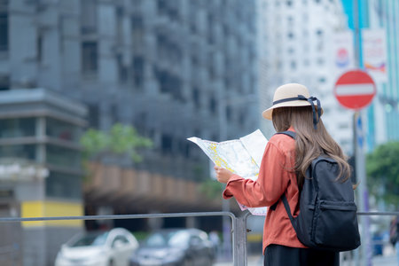 Asian tourist, cute woman with long hair are traveling in Hong Kong along with map and her camera with fun on her holiday,traveler relaxing and enjoying at  Hong Kong.の写真素材