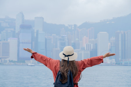 Asian tourist, cute woman with long hair are traveling in Hong Kong along with map and her camera with fun on her holiday,traveler at Victoria harbour in Hong Kong.の写真素材