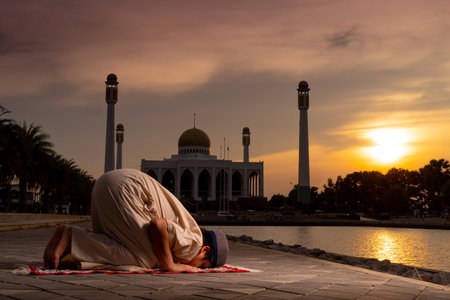 A little Asian Muslim boy is praying with peace in the beautiful mosque, giving a powerful atmosphere of faith, with copy space, Islam concept.の写真素材