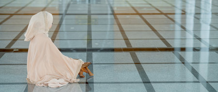 The image of an Asian Muslim woman in the Islamic religion in hijab in white color. reading the Quran, Koran Staying in a beautiful mosque. panoramic bannerの写真素材