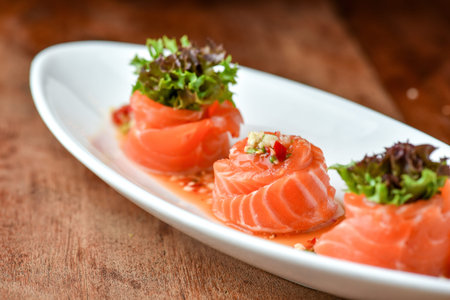 Sliced salmon sashimi on white plate, Japanese food