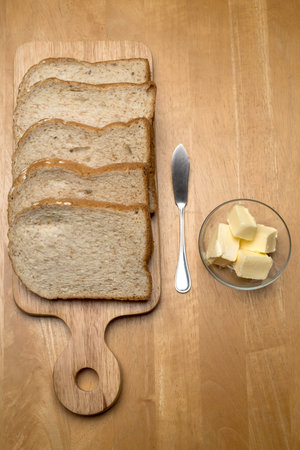 Sliced bread and butter on a wooden board. Top view.の写真素材