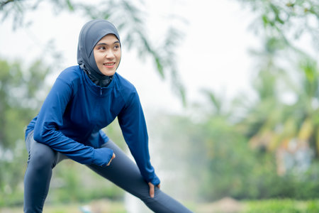 Asian cute muslim woman wearing sportswear and a blue hijab Exercising and running outdoors at the park in the morning. with a fresh feeling.の写真素材