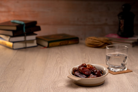 Many Date Palms are on bowls, plates, a cup of water, and the Quran and Islamic style lamps on...