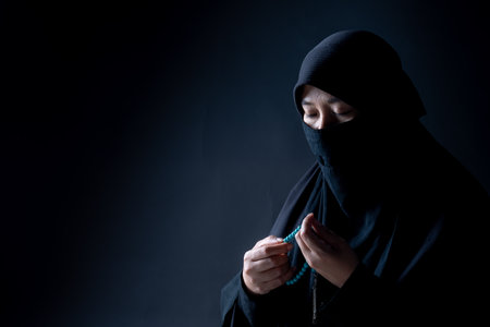 Portrait Asian Muslim woman standing and reading the Quran and appreciates and faith The Holy Al Quran with written Arabic calligraphy meaning of Al Quranの写真素材