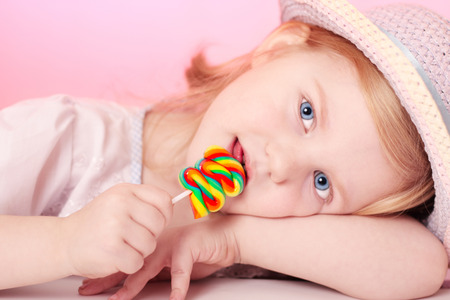 girl with lollipop on pink backgroundの写真素材