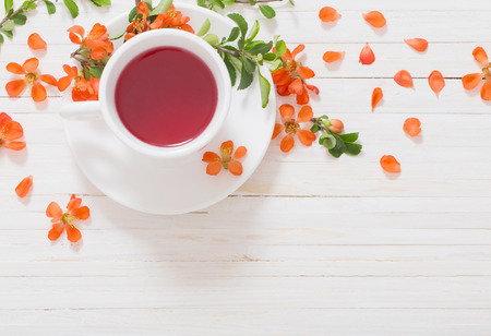 still life with cup of tea and orange flowersの写真素材
