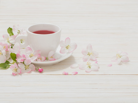 Red tea with flowers on white wooden backgroundの写真素材