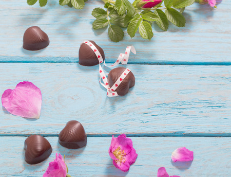 pink rose and chocolate on wooden backgroundの写真素材