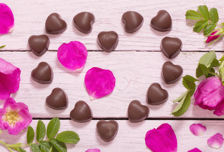 pink rose and chocolate on wooden backgroundの写真素材